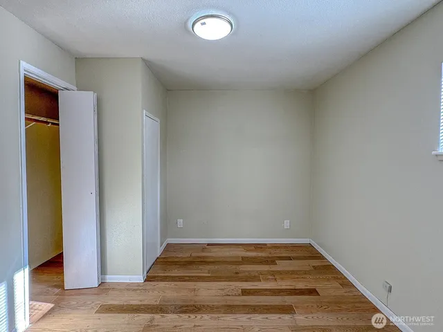 a view of empty room with wooden floor