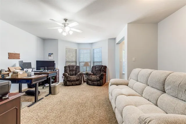 a living room with furniture ceiling fan and a rug