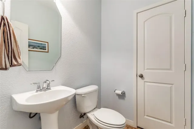 a bathroom with a sink toilet and a mirror