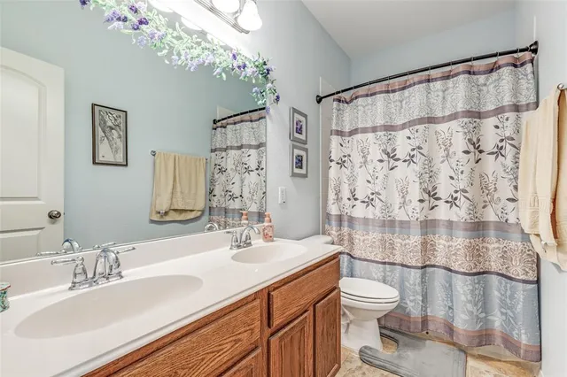 a bathroom with a sink vanity granite toilet and shower