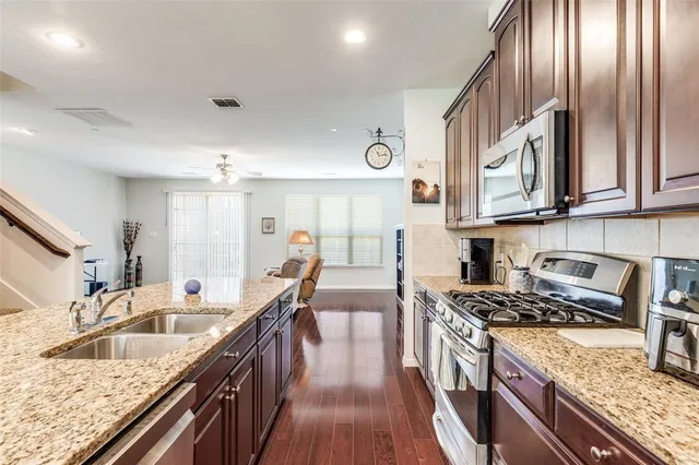 a kitchen with stainless steel appliances granite countertop a sink stove and cabinets