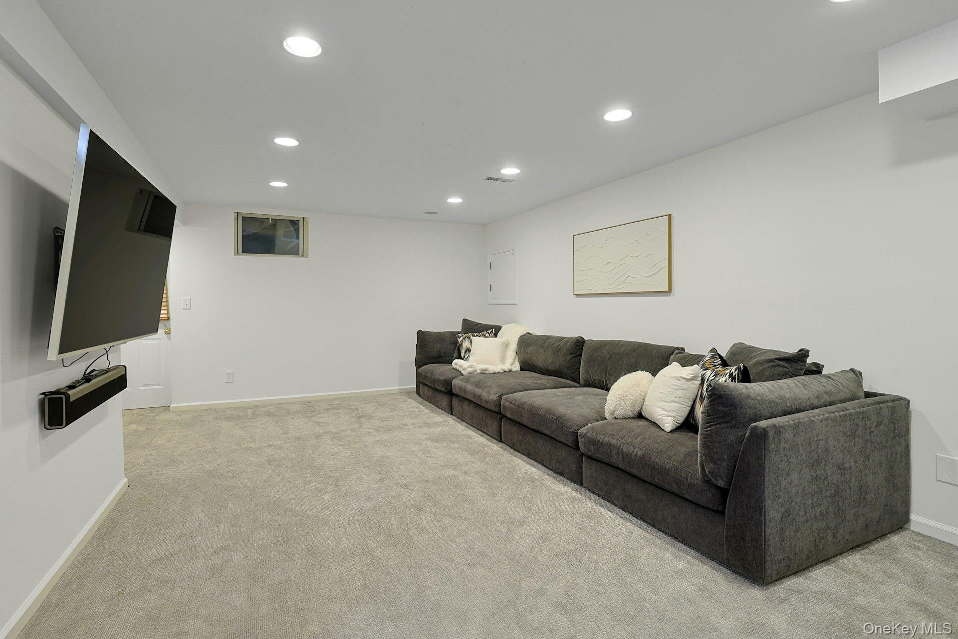 250 Mamaroneck Road Scarsdale, NY 10583 - Photo 26 of 35 Large, versatile recreation room offering flexible space for media, play or exercise, updated in 2021 with new carpet and freshly painted. Not shown here is an oversized walk-in closet with built-in shelving and an egress door to the backyard.