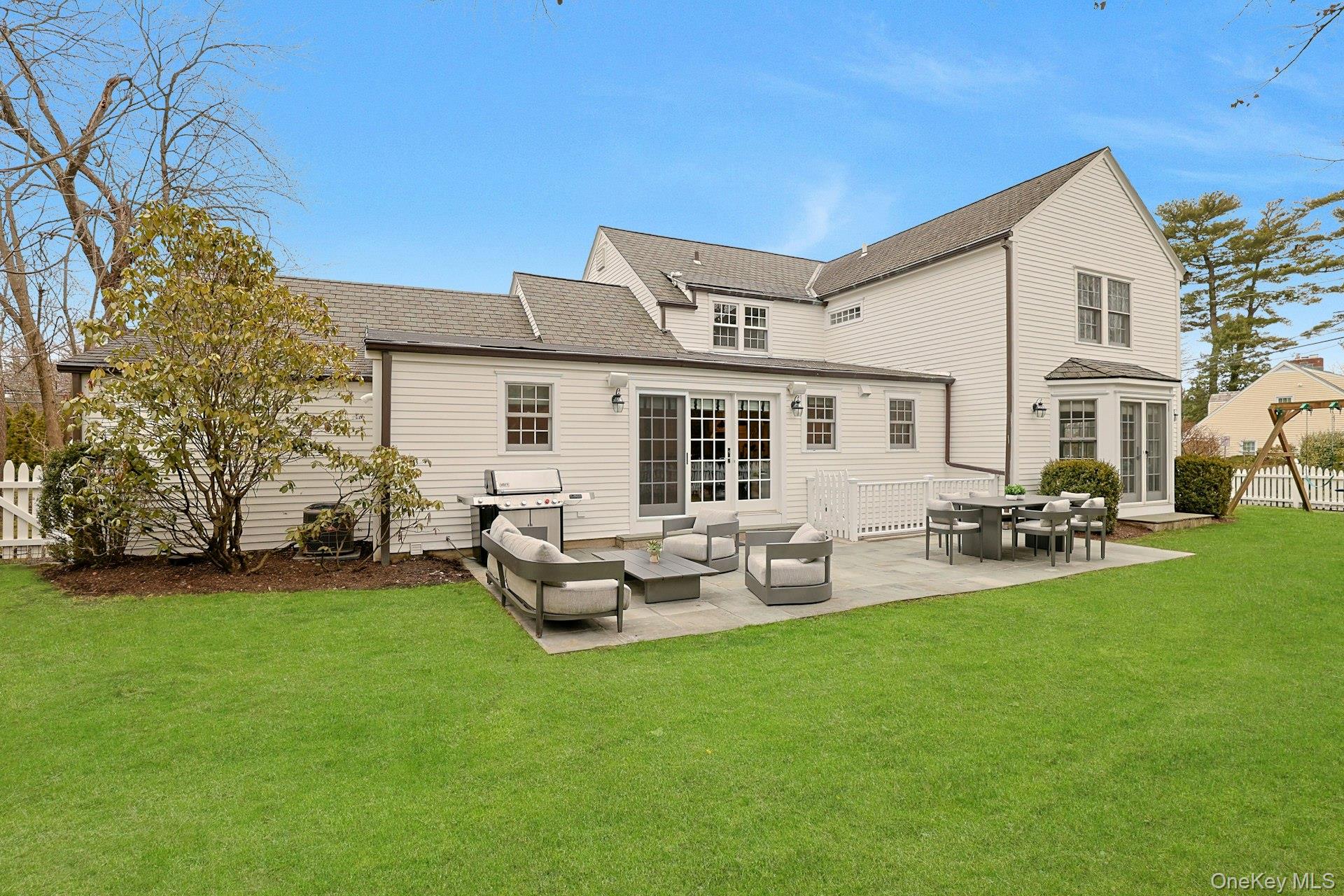 250 Mamaroneck Road Scarsdale, NY 10583 - Photo 28 of 35 Fully fenced, level backyard ideal for recreation or relaxing, featuring a bluestone patio with access from the kitchen and family room, plus garden lighting added in 2025.