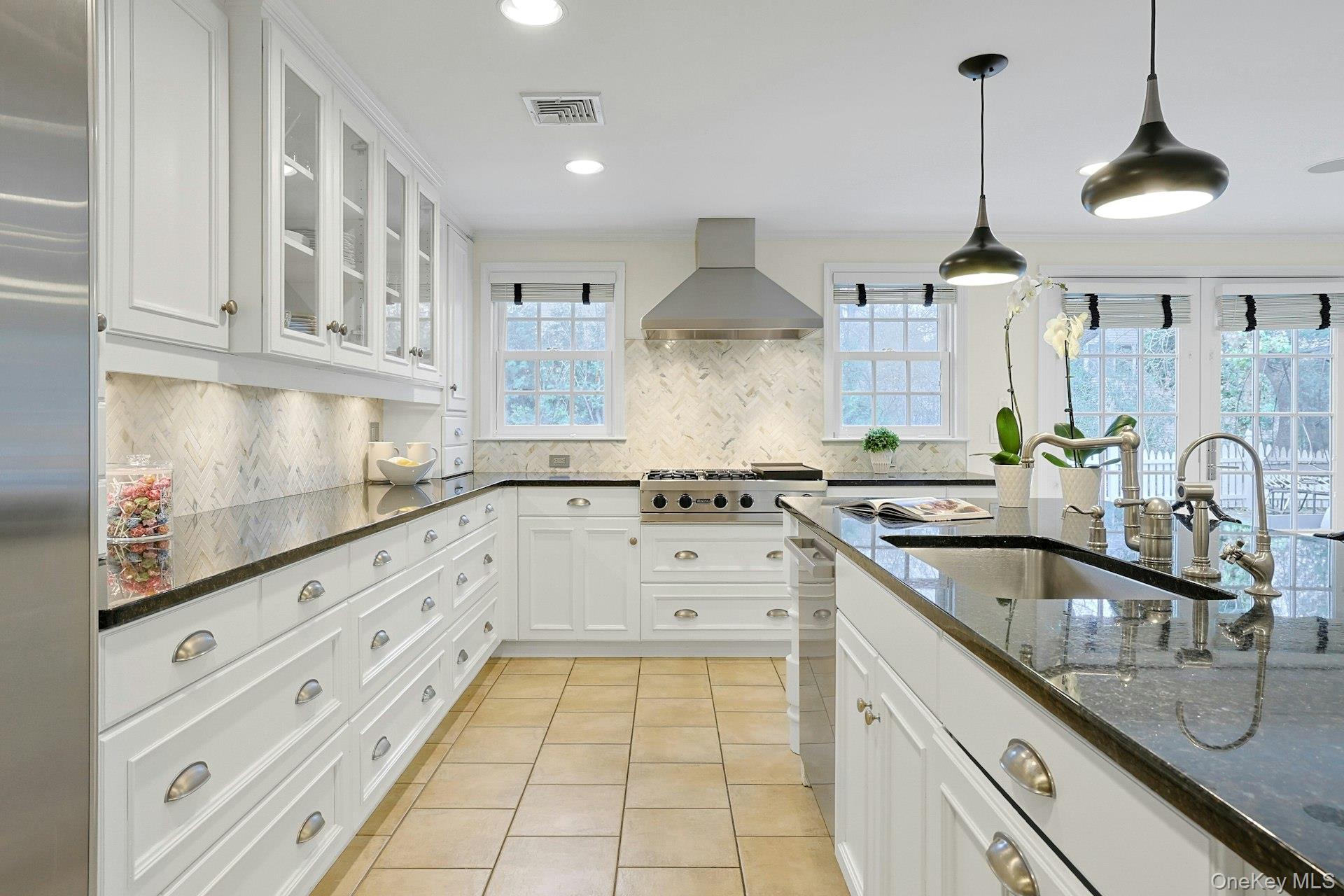 250 Mamaroneck Road Scarsdale, NY 10583 - Photo 10 of 35 Lined with windows that fill the space with natural light, the kitchen offers exceptional storage with extensive custom cabinetry along with generous countertop space for effortless prep and serving.