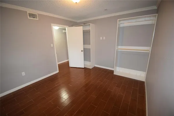 a view of empty room with wooden floor