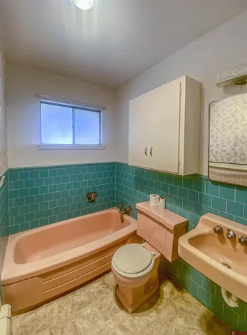 a bathroom with a toilet sink and mirror