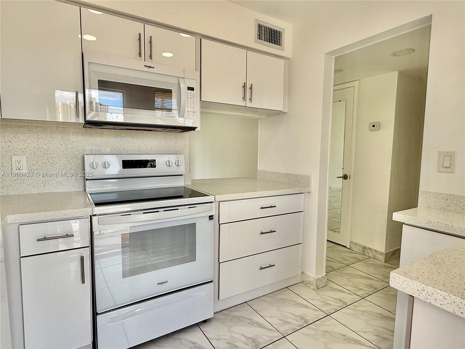 a kitchen with white cabinets stainless steel appliances and sink