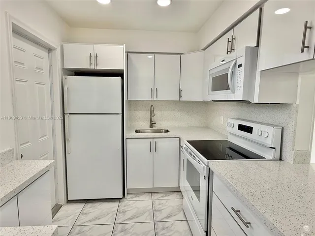 a kitchen with cabinets and white appliances