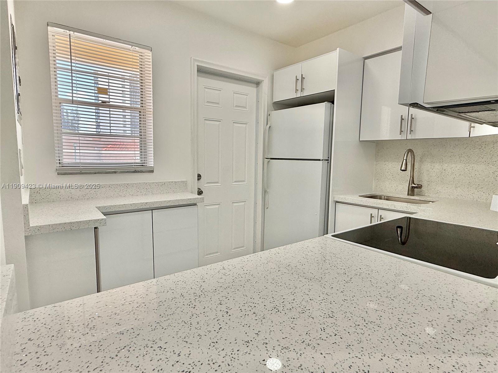 20201 Northeast 29th Court, Unit D221 Aventura, FL 33180 - Photo 8 of 13 a kitchen with stainless steel appliances granite countertop a sink refrigerator and cabinets