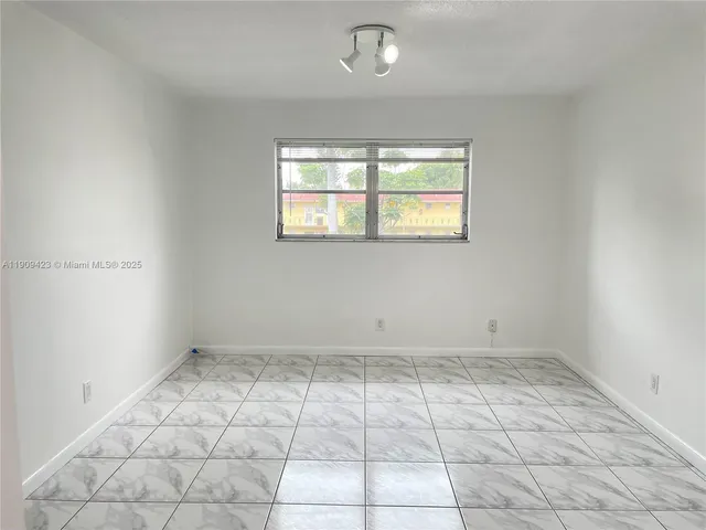 an empty room with white walls and tiles