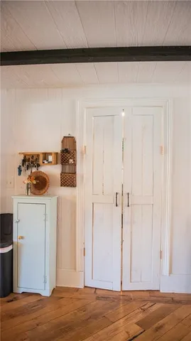 a living room with furniture a flat screen tv and a refrigerator