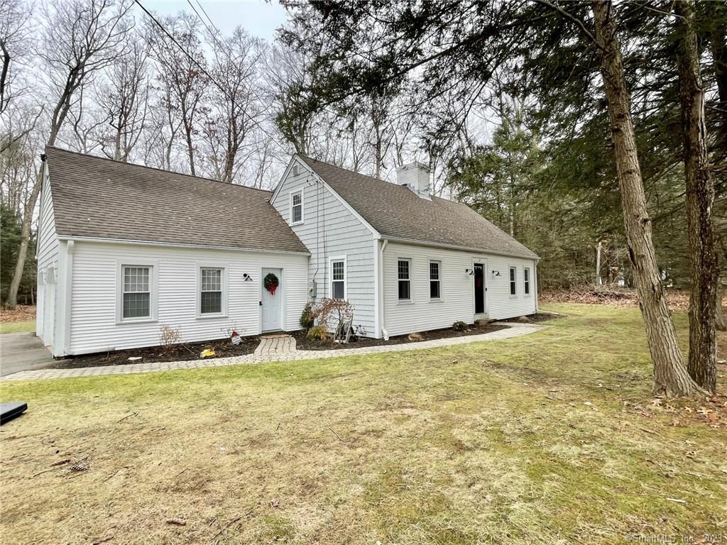 a view of a house with backyard and trees