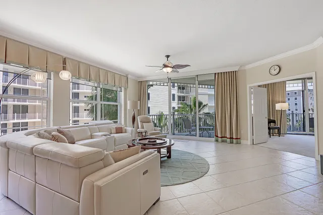 a living room with furniture a flat screen tv and kitchen view