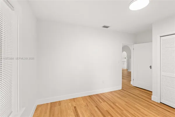 a view of an empty room with wooden floor