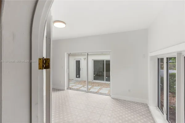 an empty room with sliding door and windows