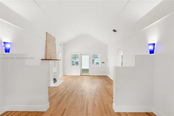 a view of a bedroom with wooden floor and cabinet