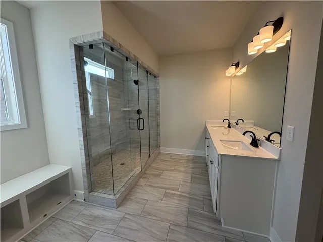 a bathroom with a sink mirror and shower