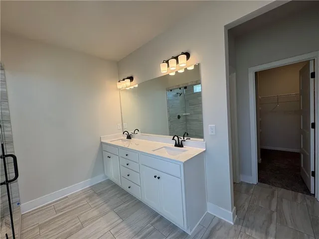 a spacious bathroom with a double vanity sink and a mirror