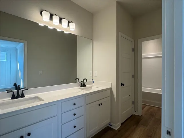 a bathroom with a double vanity sink and a mirror