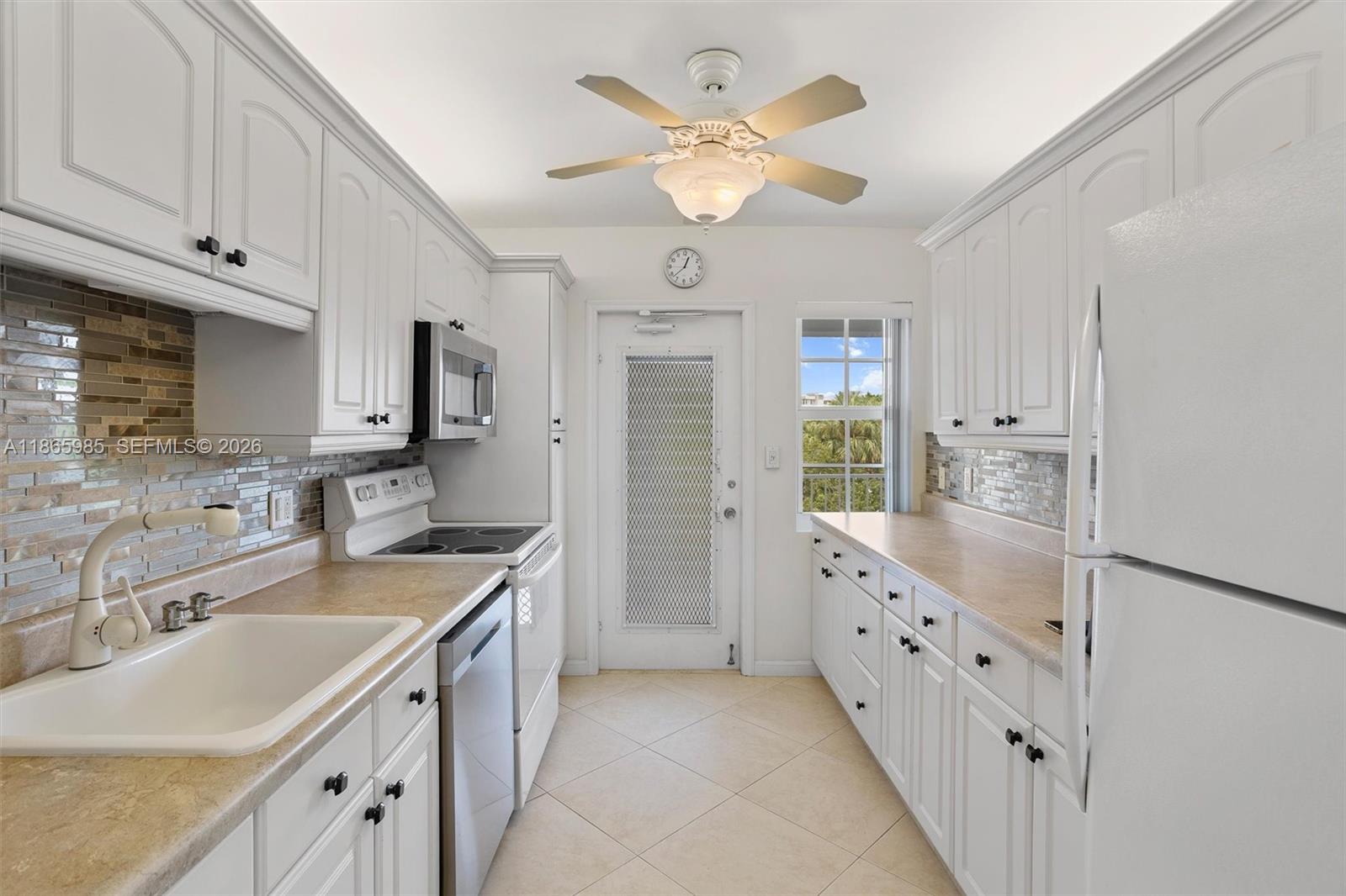 3150 North Course Lane, Unit 402 Pompano Beach, FL 33069 - Photo 11 of 29 a kitchen with cabinets a sink and appliances
