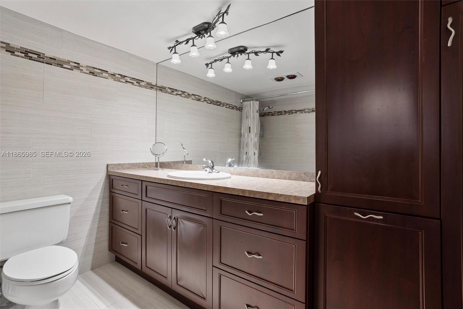 3150 North Course Lane, Unit 402 Pompano Beach, FL 33069 - Photo 16 of 29 a bathroom with a toilet a sink and mirror