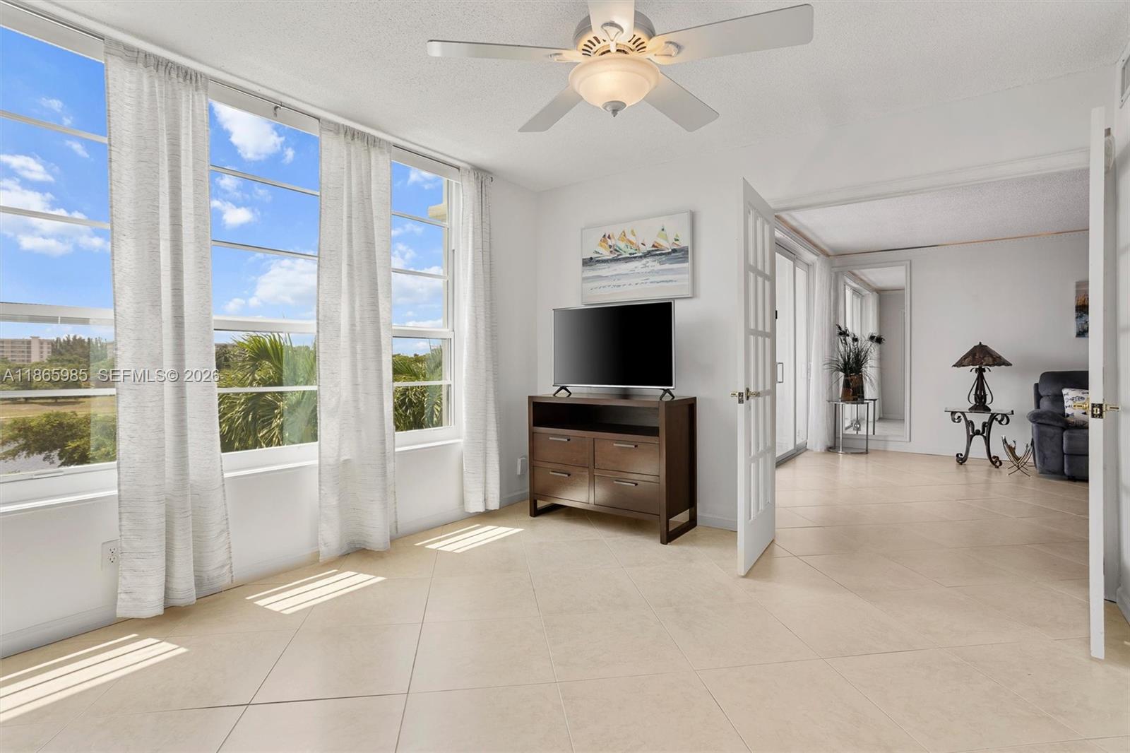 3150 North Course Lane, Unit 402 Pompano Beach, FL 33069 - Photo 19 of 29 a living room with furniture a fireplace and a flat screen tv