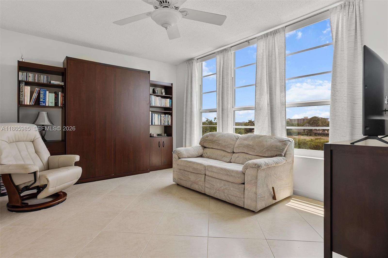 3150 North Course Lane, Unit 402 Pompano Beach, FL 33069 - Photo 2 of 29 a living room with furniture and a flat screen tv