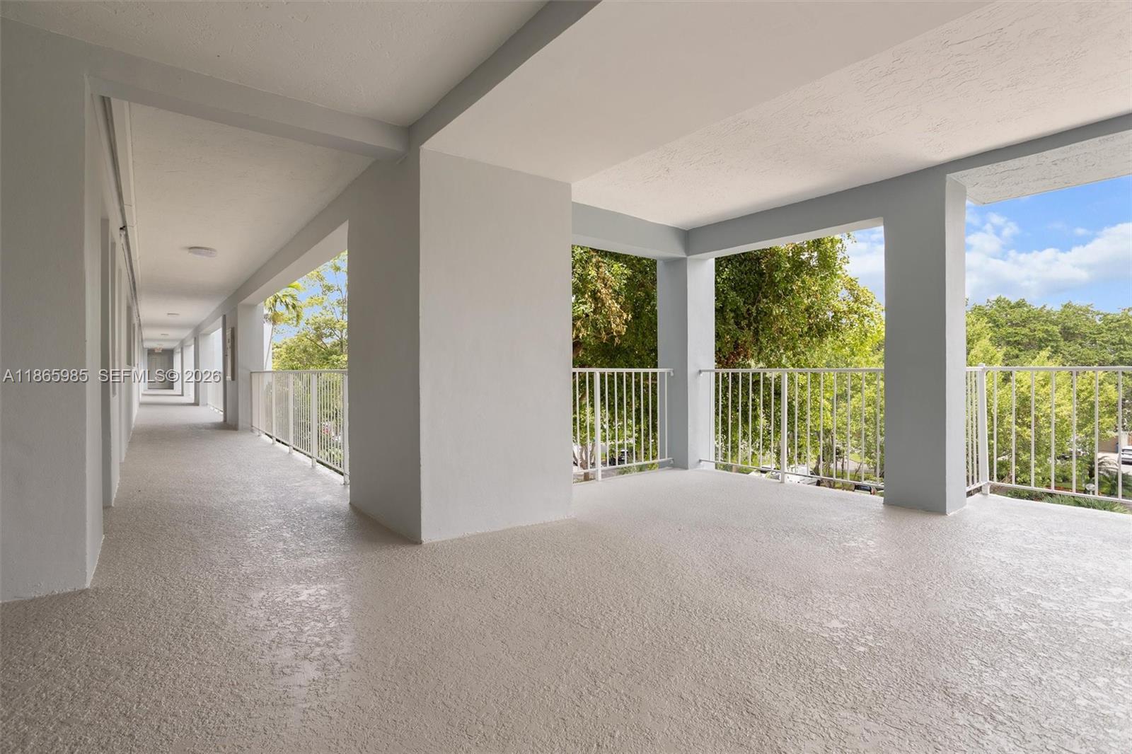3150 North Course Lane, Unit 402 Pompano Beach, FL 33069 - Photo 22 of 29 a view of an empty room with windows and a balcony