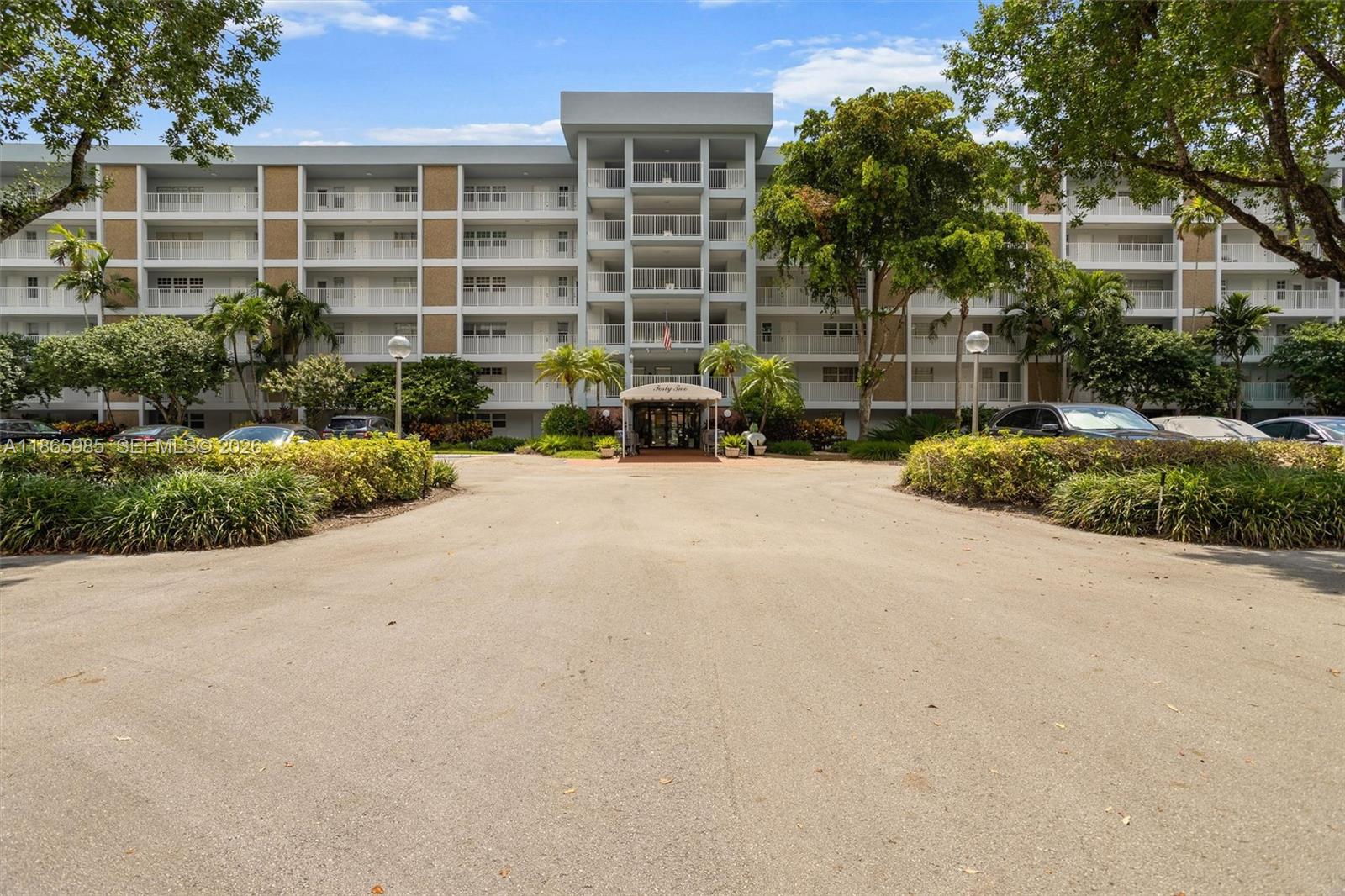 3150 North Course Lane, Unit 402 Pompano Beach, FL 33069 - Photo 23 of 29 a front view of a house with a yard and outdoor seating