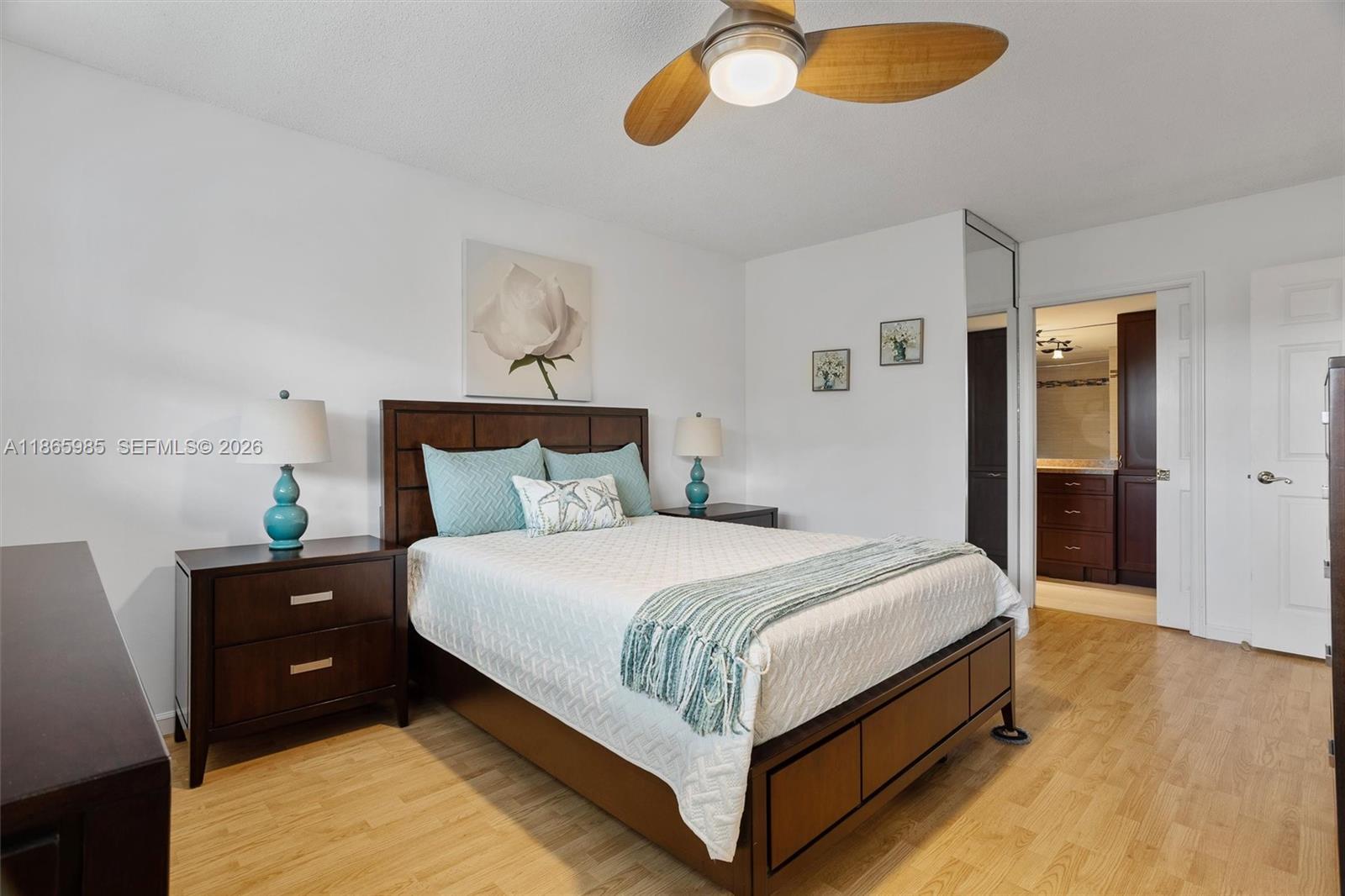 3150 North Course Lane, Unit 402 Pompano Beach, FL 33069 - Photo 3 of 29 a bedroom with a bed and a chandelier