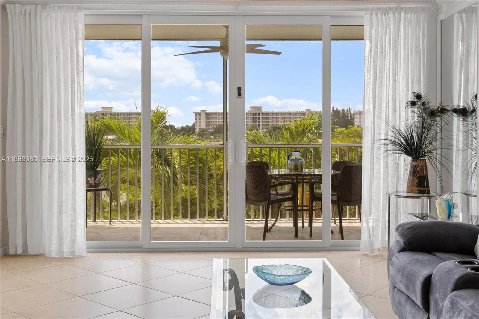 3150 North Course Lane, Unit 402 Pompano Beach, FL 33069 - Photo 4 of 29 a living room with furniture and a floor to ceiling window