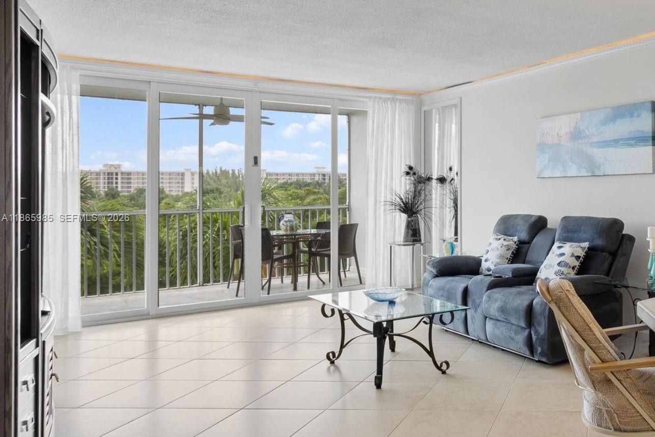 3150 North Course Lane, Unit 402 Pompano Beach, FL 33069 - Photo 9 of 29 a living room with furniture and a large window