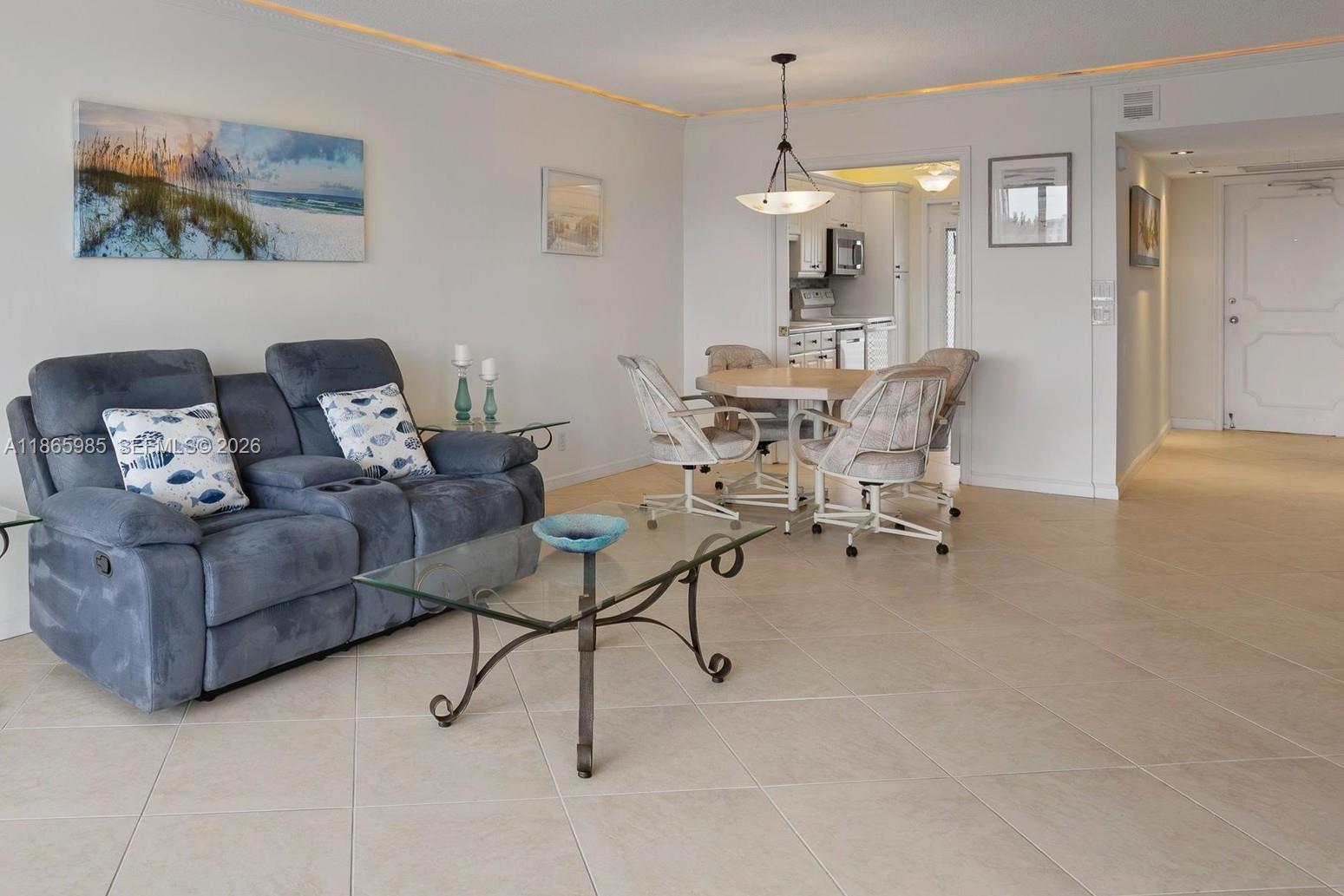 3150 North Course Lane, Unit 402 Pompano Beach, FL 33069 - Photo 10 of 29 a living room with furniture and a chandelier