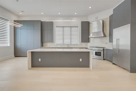 a kitchen with stainless steel appliances granite countertop a sink a stove and a refrigerator