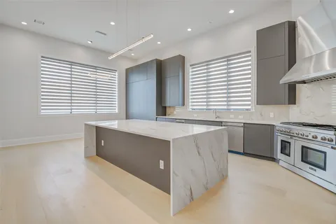 a large white kitchen with a large window