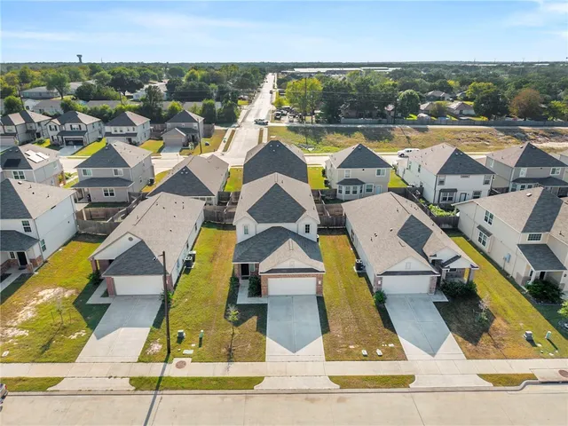 an aerial view of residential houses with outdoor space and swimming pool