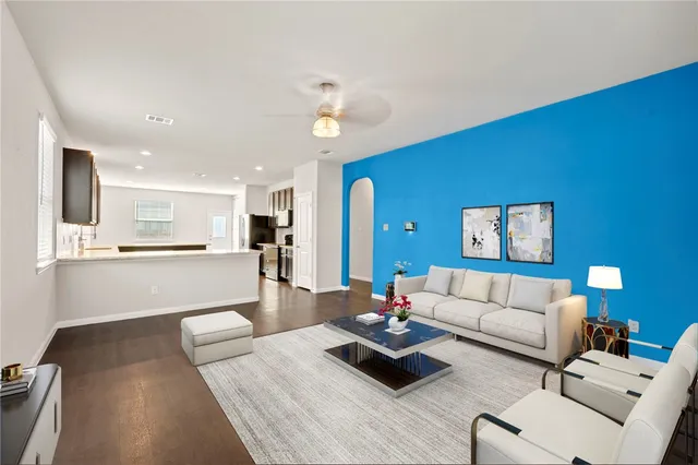 a living room with furniture and view of kitchen