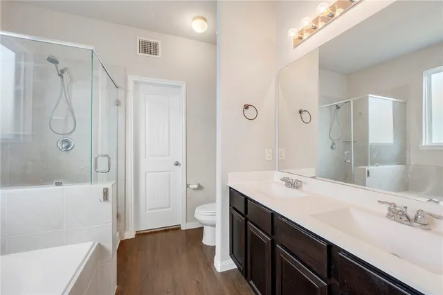 a bathroom with a double vanity sink a large mirror and shower