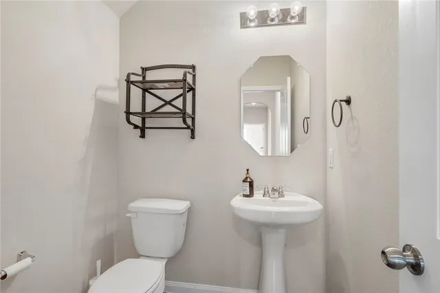 a bathroom with a toilet a sink and mirror