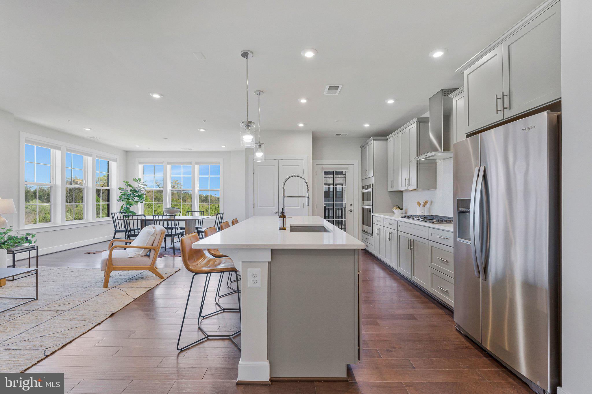 2320 Field Point Road, Unit 4304 Herndon, VA 20171 - Photo 12 of 42 a kitchen with stainless steel appliances granite countertop a refrigerator a sink dishwasher a stove and a dining table with wooden floor