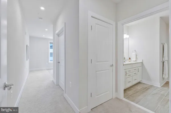 a view of a hallway with closet and mirror