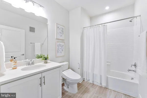 a bathroom with a sink a toilet and a large mirror