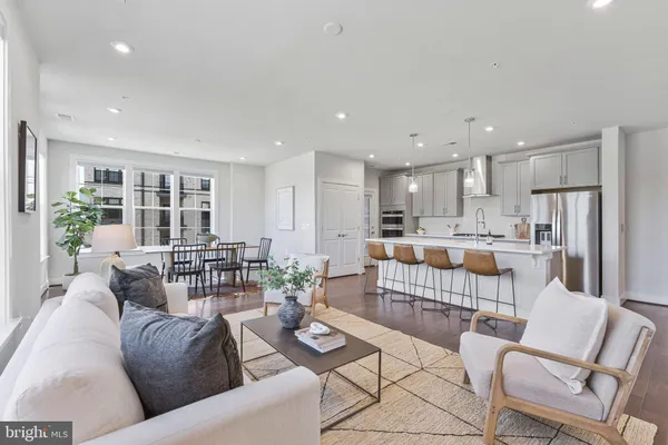 a living room with furniture and a view of kitchen