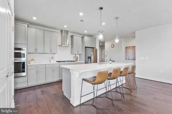 a kitchen with kitchen island granite countertop wooden floors and white cabinets