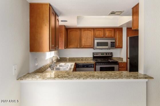 17211 North 35th Avenue, Unit B207 Phoenix, AZ 85053 - Photo 11 of 17 a kitchen with granite countertop a sink and a stove top oven