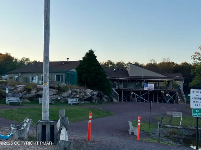 a view of a lake with a bench under large trees