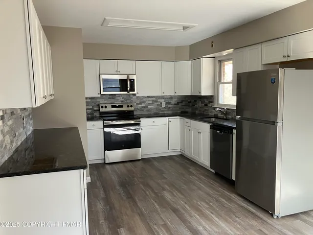 a view of a refrigerator in kitchen and wooden floor