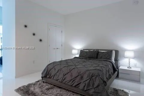 a bedroom with a bed and a night stand