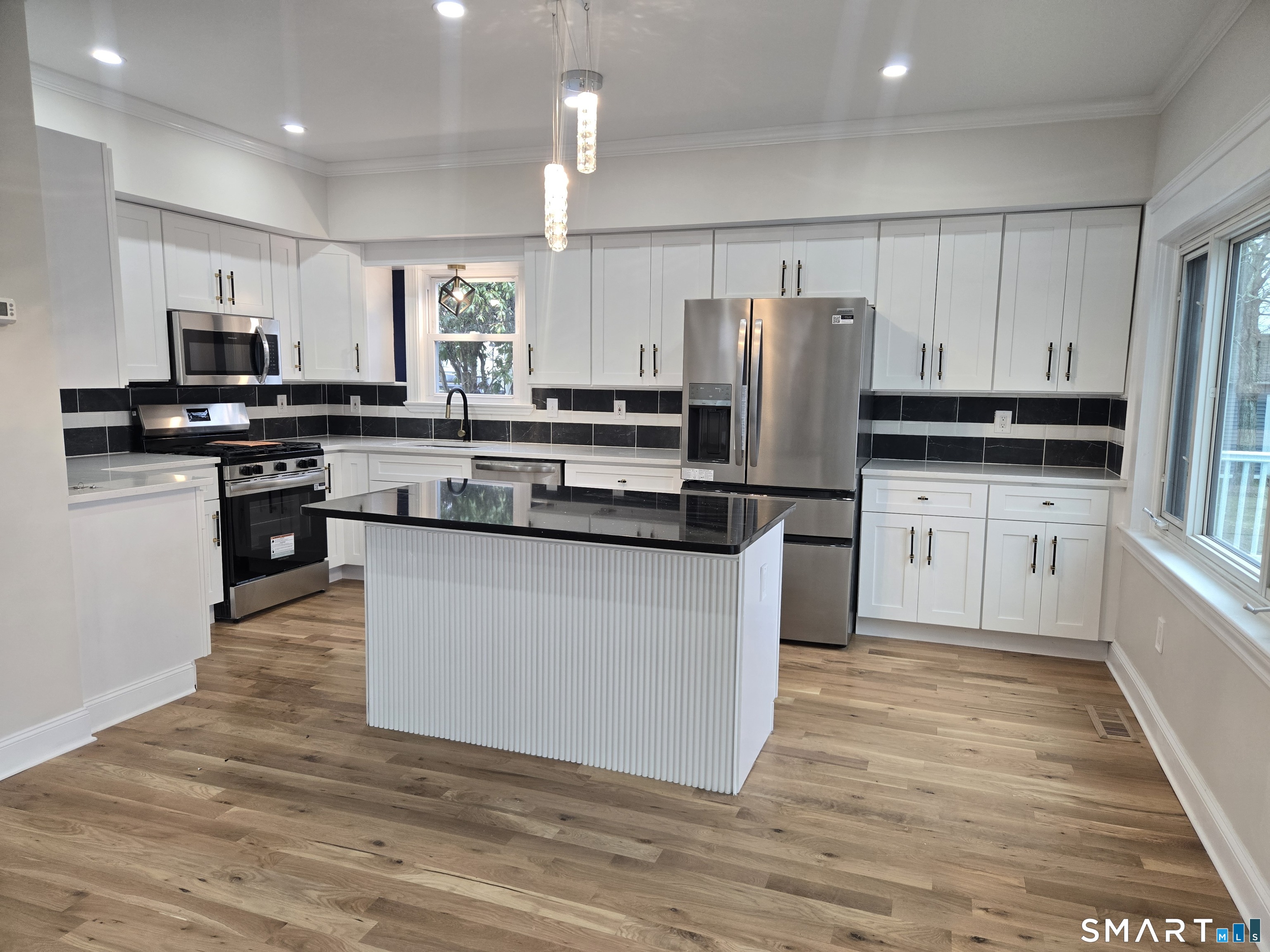 8 Pine Street Norwich, CT 06360 - Photo 13 of 27 a kitchen with stainless steel appliances granite countertop a refrigerator a stove a sink and a microwave