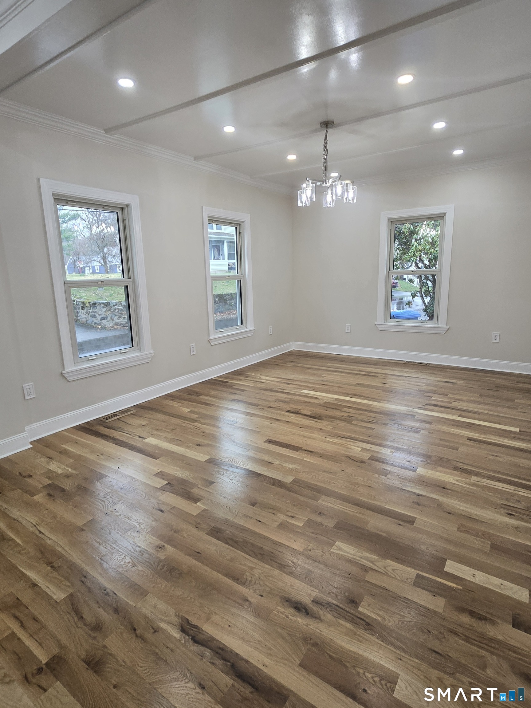 8 Pine Street Norwich, CT 06360 - Photo 15 of 27 an empty room with wooden floor ceiling fan and windows